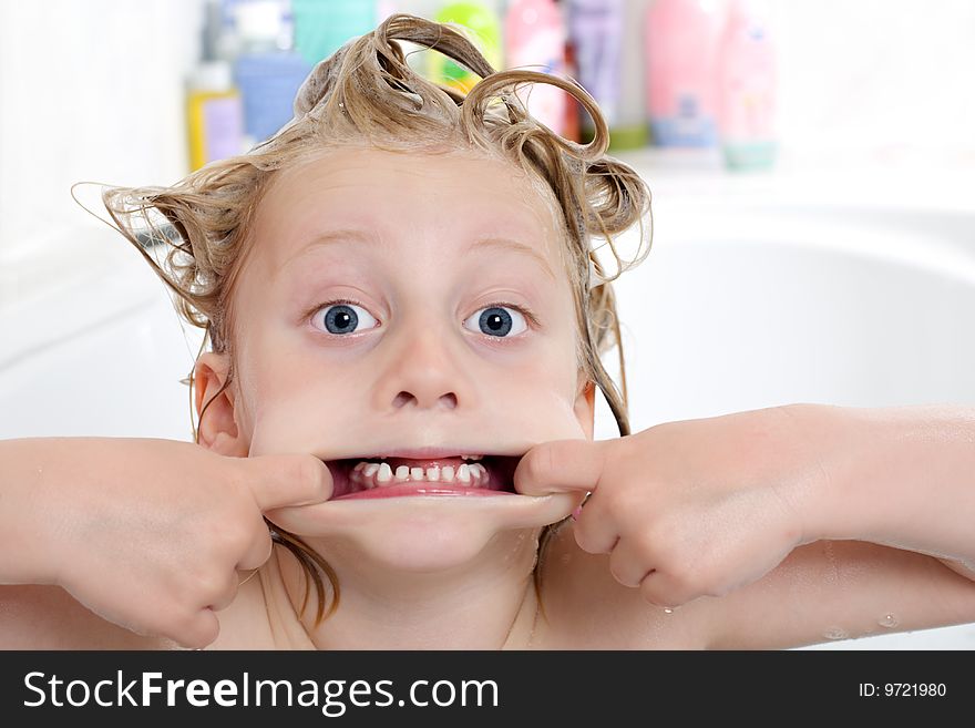 Young child is sitting in bath tub and makes a grimace. Young child is sitting in bath tub and makes a grimace
