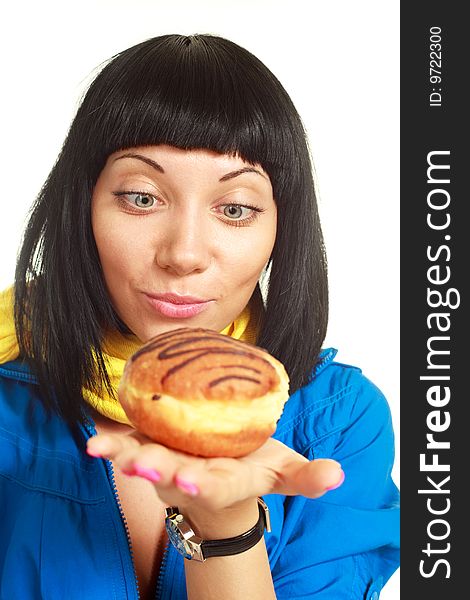 Pretty young brunette woman eating a roll with chocolate. Pretty young brunette woman eating a roll with chocolate