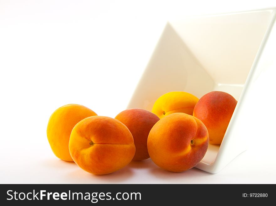 Spilt bowl of apricots with white background with clipping path
