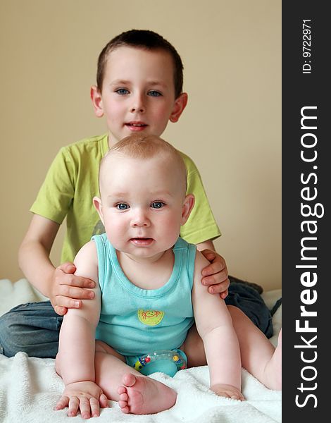 Portrait of two brothers. 7 months old baby boy and 5 years old preschooler. Kids smiling and having fun. Portrait of two brothers. 7 months old baby boy and 5 years old preschooler. Kids smiling and having fun.