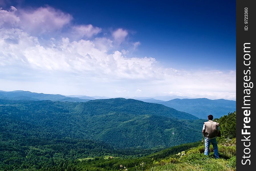 Man on the mountain enjoying scenery. Man on the mountain enjoying scenery.