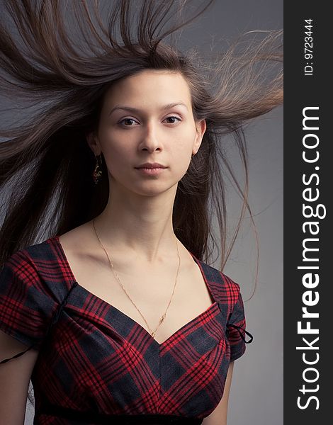 Woman with fluttering hair. On dark background.