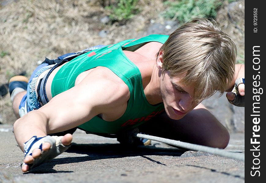 A male rock climber climbing a cliff