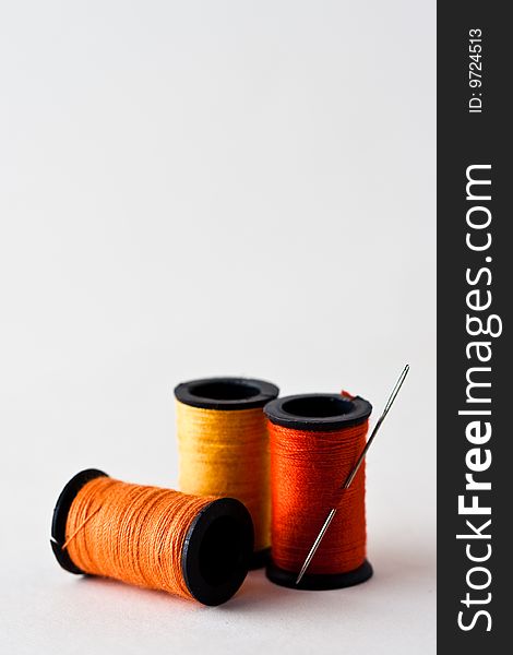 Three spools of thread with needle. Three spools of thread with needle.