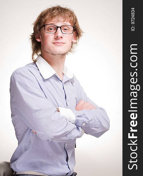 Closeup portrait of  young man in glasses with crossed hands. Closeup portrait of  young man in glasses with crossed hands