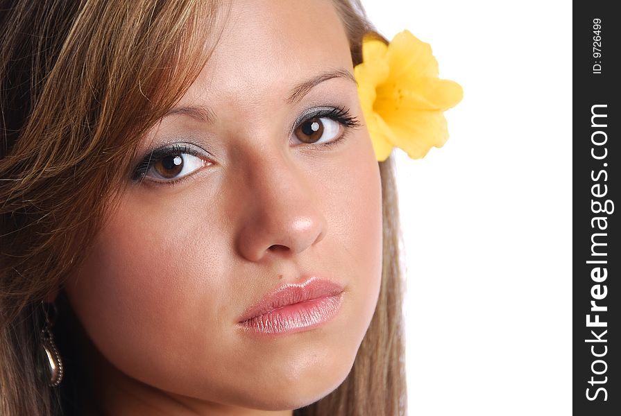 Closeup of a pretty girl's face with a yellow flower. Closeup of a pretty girl's face with a yellow flower.