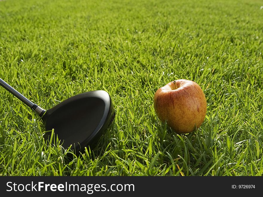 Golfer preparing to drive an apple downrange. Golfer preparing to drive an apple downrange.