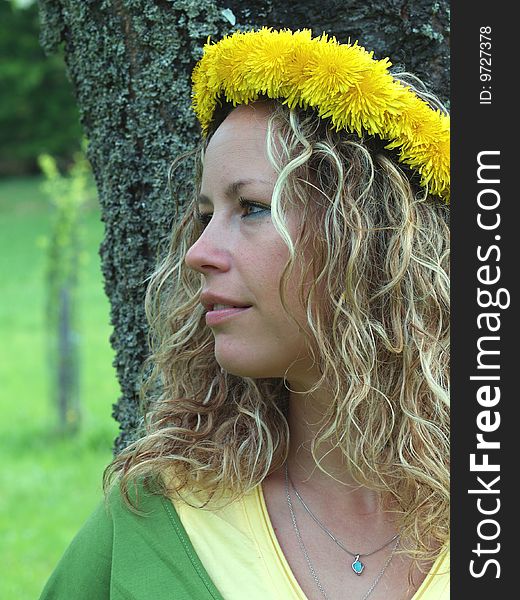 Curly girl with dandelion chain on head