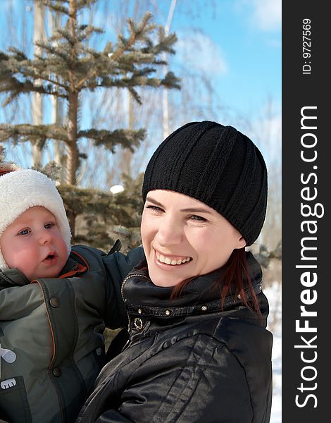 Portrait of young mum with the son in the winter on walk. Portrait of young mum with the son in the winter on walk