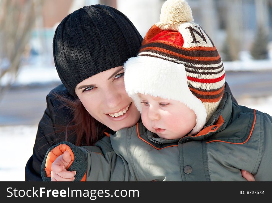 Portrait of young mum with the son in the winter on walk. Portrait of young mum with the son in the winter on walk