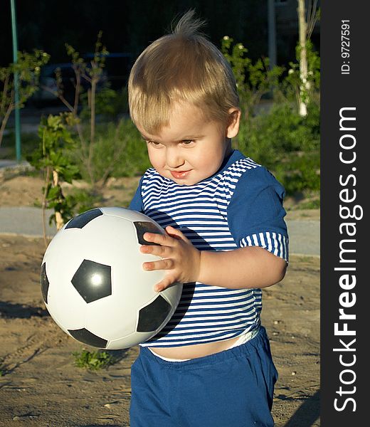 The boy with a football on walk. The boy with a football on walk