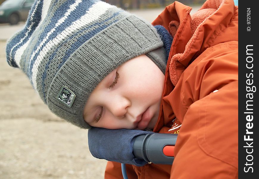 The little boy sleeps in the street in the spring. The little boy sleeps in the street in the spring