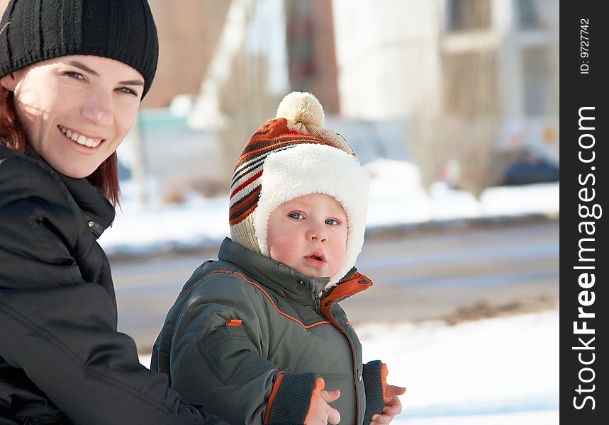 Portrait of young mum with the son in the winter on walk. Portrait of young mum with the son in the winter on walk