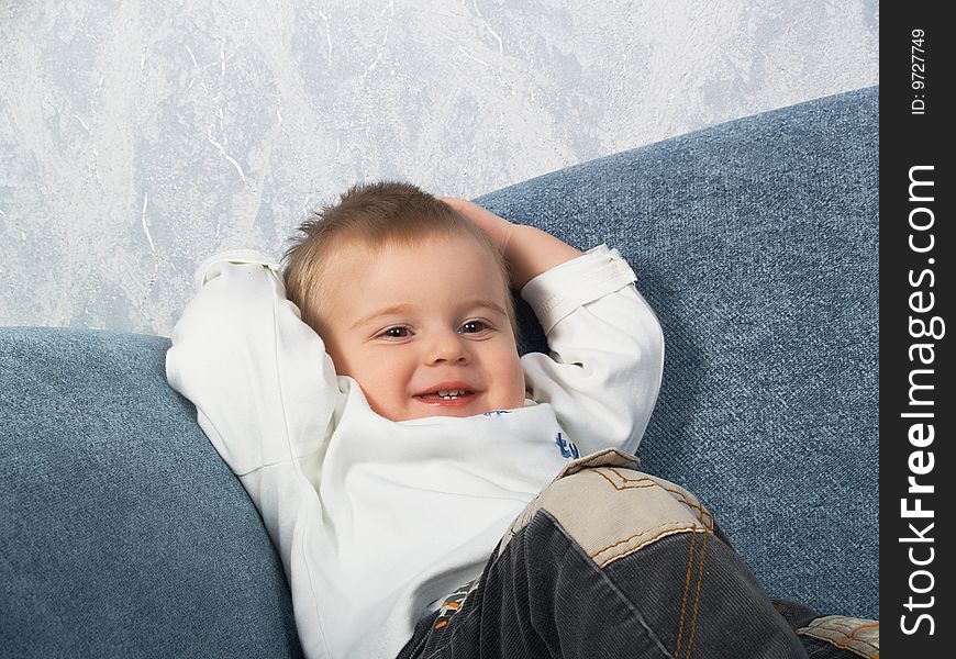 The little boy lays on a sofa of the house. The little boy lays on a sofa of the house