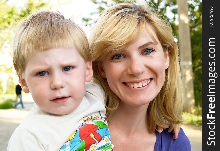Woman and young boy outdoors embracing and smiling. Woman and young boy outdoors embracing and smiling