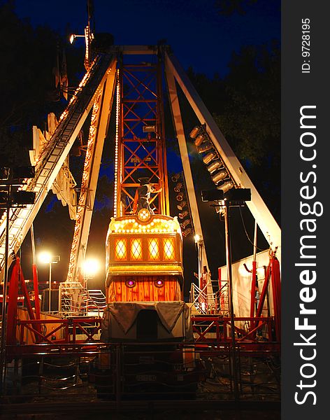 Illuminated Construction of carousel in evening park