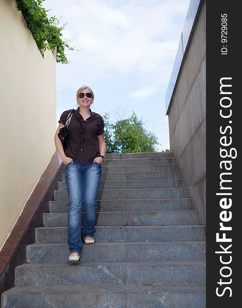 Beautiful girl goes downwards on a ladder. Beautiful girl goes downwards on a ladder