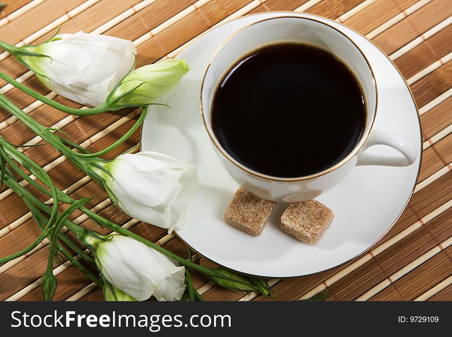 Cup of coffee with sugar and flowers near cup. Cup of coffee with sugar and flowers near cup