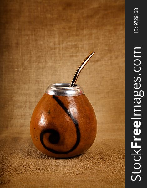 Argentinean Calabash cup with Bombilla over canvas background, selective focus