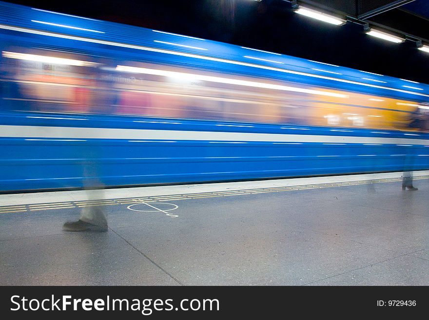 Moving blue train people walking