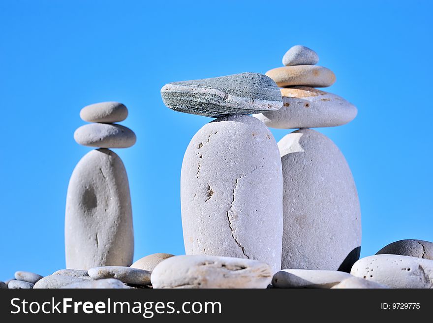 Balance of small stones on three long cobblestones. Balance of small stones on three long cobblestones