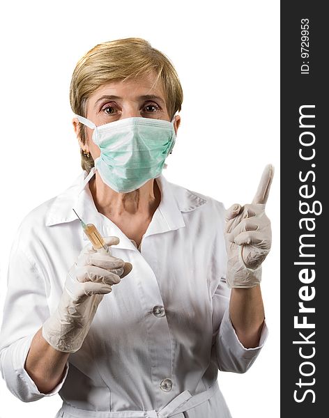 Mature woman doctor wearing protective mask , holding a syringe and pointing upwards to copy space isolated on white background,check also Medical. Mature woman doctor wearing protective mask , holding a syringe and pointing upwards to copy space isolated on white background,check also Medical