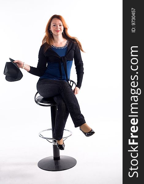 Young girl with  black hat sitting on chair on white background. Young girl with  black hat sitting on chair on white background