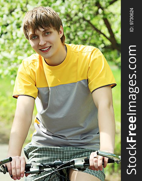 Sporty young man cycling in a park. Sporty young man cycling in a park.