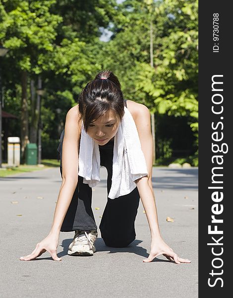 An asian girl preparing to run