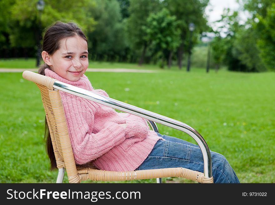 Girl sits on a chair against the nature. Girl sits on a chair against the nature