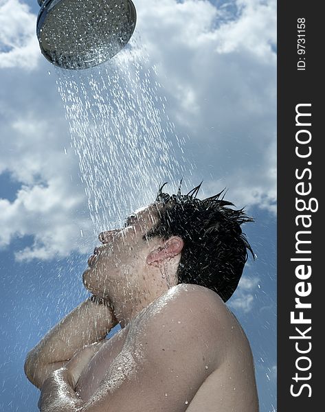 A young man under outdoor shower