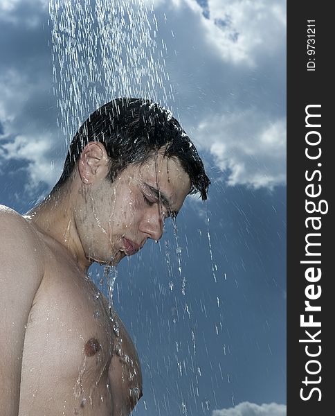 A young man under outdoor shower