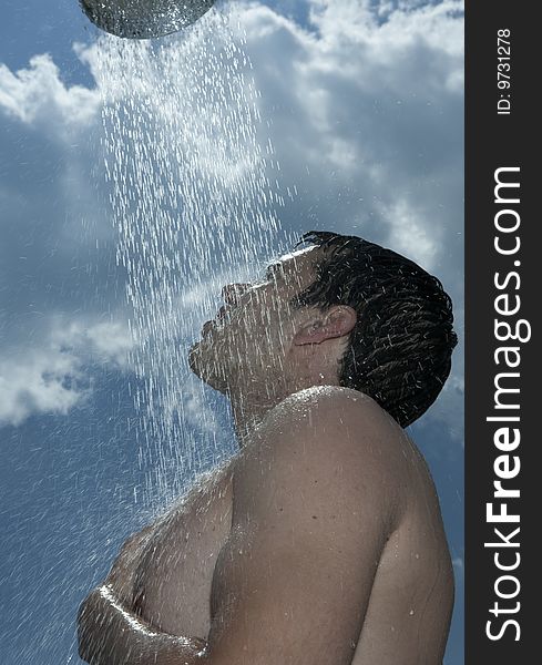 A young man under outdoor shower