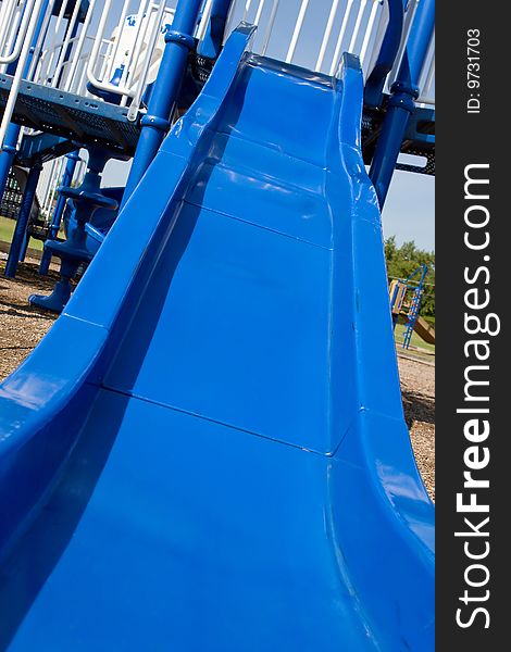 Blue slide attached to a large playground. Blue slide attached to a large playground.