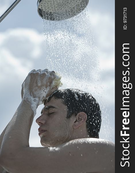 A young man under outdoor shower