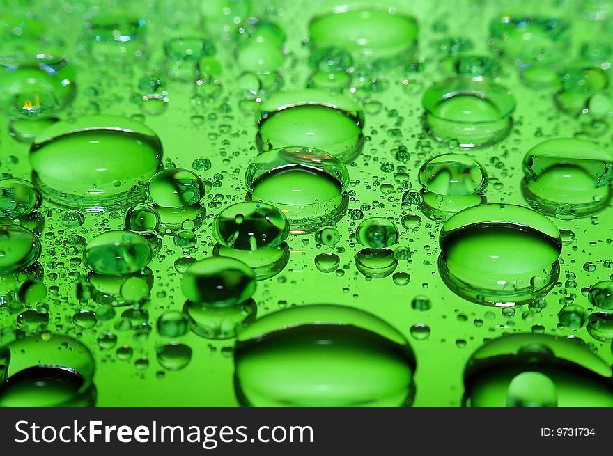 Large green drops raining on glass