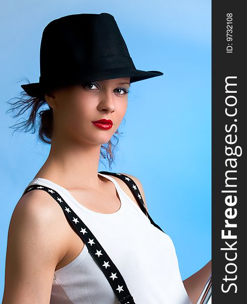 Beautiful woman with back hat posing in studio