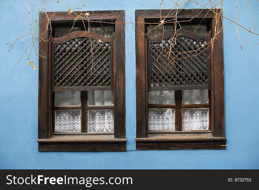 Two old wooden windows and blue adobe wall. Two old wooden windows and blue adobe wall