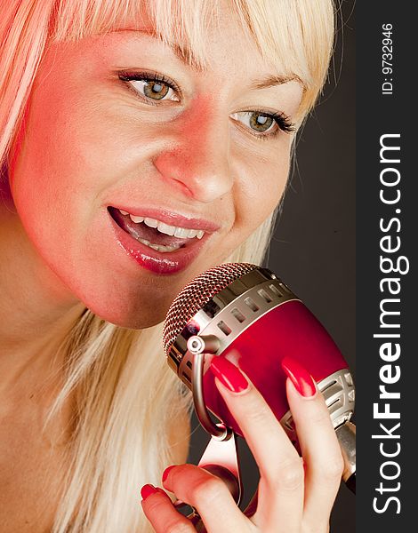 Young long hair blonde woman sing to retro microphone. Young long hair blonde woman sing to retro microphone