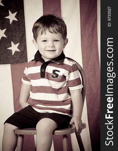 Little boy sitting in a chair with american flag. Little boy sitting in a chair with american flag