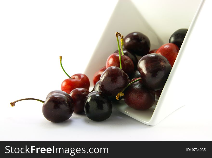 Spilt bowl of cherries with white background with clipping path