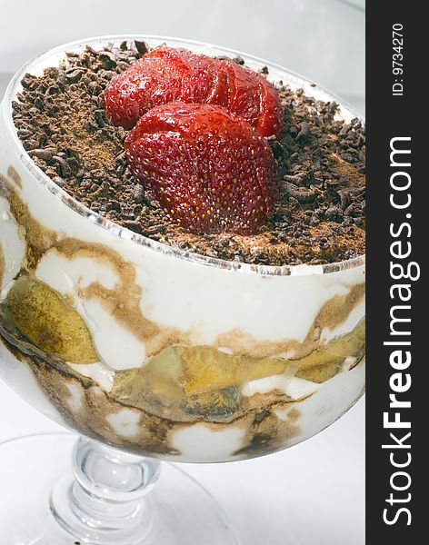 Tiramisu dessert with strawberry in cup of glass, vertical view