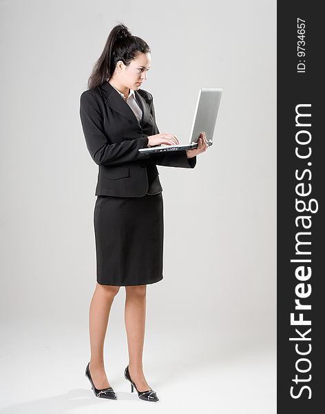 Businesswoman with laptop on neutral background