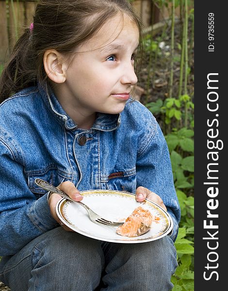 Pretty young girl sitting with plate at picnic