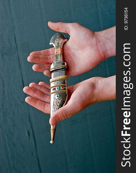 Hands holding   traditional Bedouin knife decorated with jewels