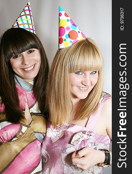 Two  Young pretty woman in birthday cap celebrating birthday. Two  Young pretty woman in birthday cap celebrating birthday