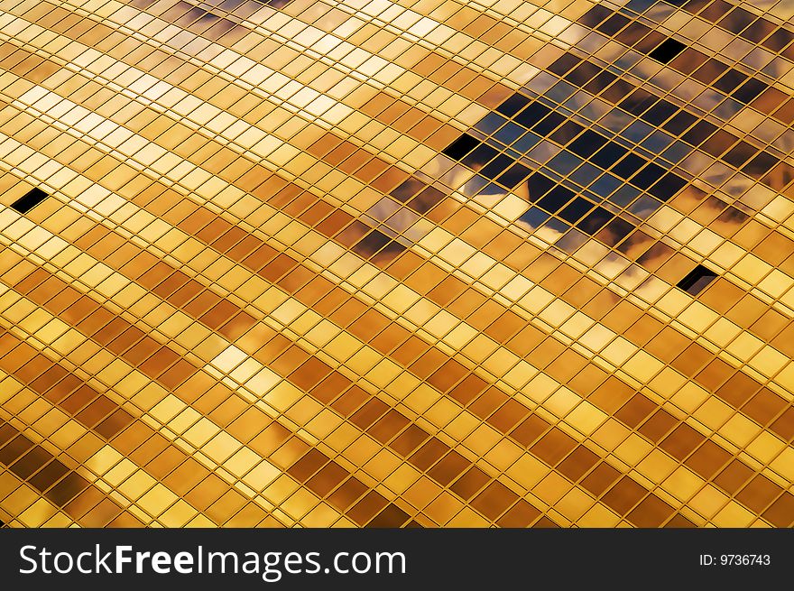 Office building gold windows with clouds mirror