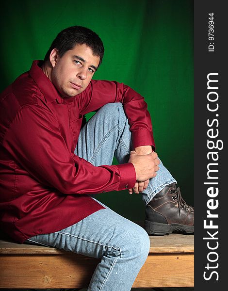 Portrait of a man sitting ona bench with a green background. Portrait of a man sitting ona bench with a green background