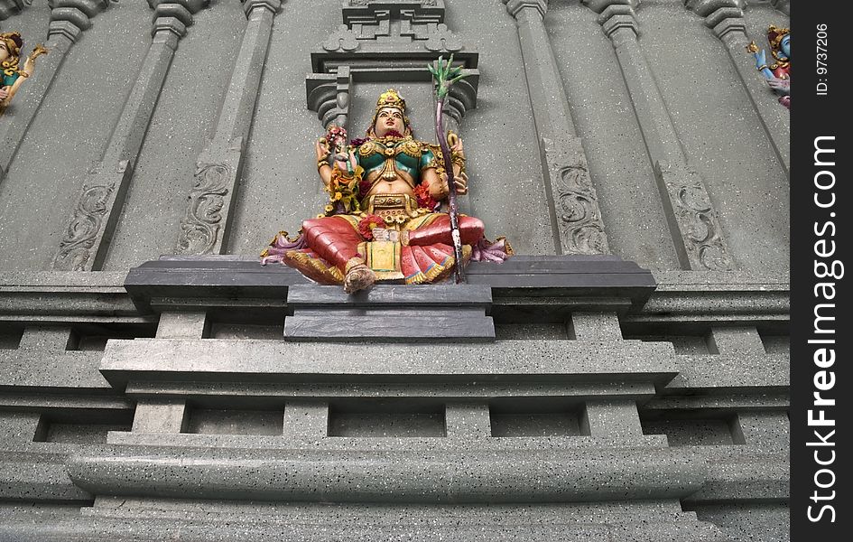 A low angle image of a colorful stone wall statue representing the Hindu deity Lakshmi, Goddess of wealth, prosperity, light, wisdom, fortune, fertility, generosity and courage; and the embodiment of beauty, grace and charm. ADOBE RGB (1998) color profile, the image is punchier than the preview.