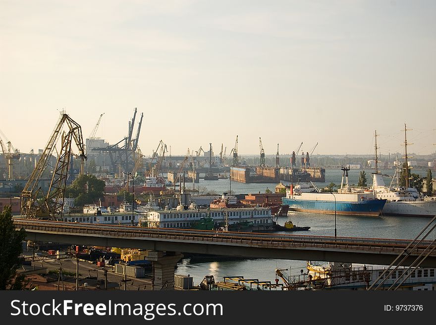 View of ship-repair yard with derricks, cranes, ships, tow boats and barges